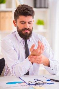 Male professional that is experiencing hand pain and hand neuropathy