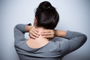 Woman that is experiencing neuropathy problems in her upper back and neck